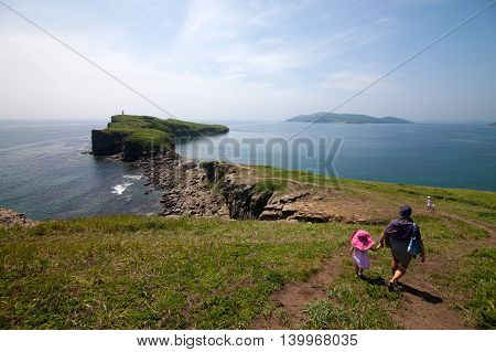 Mother with her daughters walking near sea