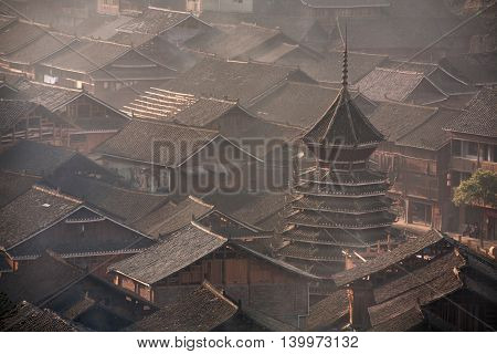 Tile roofs of wooden houses of Chinese peasants in the village of Dong ethnic minority in southwest China early misty morning spring, Zhaoxing Dong Village Guizhou Province China.