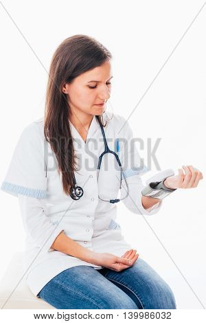Young nurse with an electronic tensiometer measuring her blood pressure
