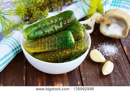 Salted cucumbers. Spices and herbs for making pickles of the wooden background