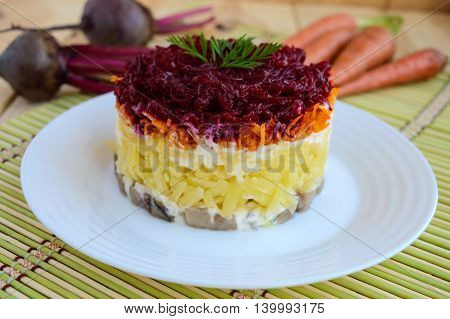Salad with layers of cooked vegetables and salted fish ("Herring under fur coat")