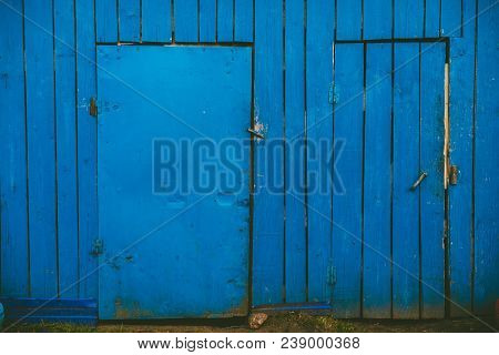 Blue Painted Double Doors On A White Painted Storage House With Two