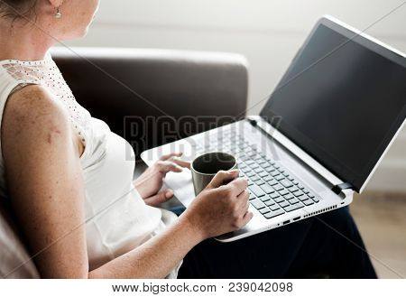 White woman using laptop at sofa