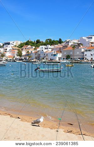 Ferragudo, Portugal - June 10, 2017 - View Of The White Town With Boats Moored On The River Arade, F