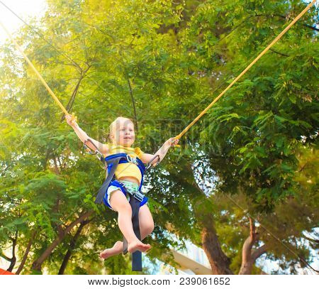 Children Summer Enterteinments. Cheerful Little Girl Jumping On Trimpoline.