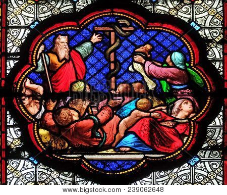 PARIS, FRANCE - JANUARY 05, 2018: Exposition of the brass serpent in the desert, prefiguration of the Crucifixion, stained glass window in the Basilica of Saint Clotilde in Paris, France.