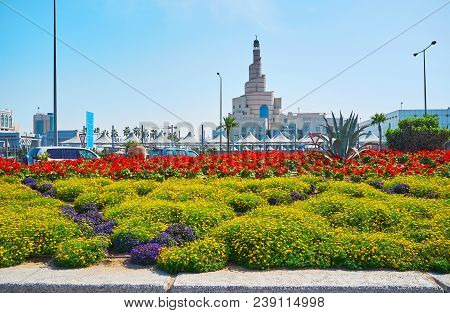 The Scenic Flower Beds In Corniche Promenade With Spiral Mosque, Also Famous As Al Fanar, On The Bac