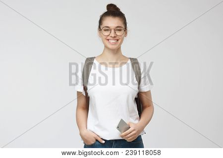 Horizontal Photo Of Young Beautiful European Woman Pictured Isolated On Grey Background Wearing Roun