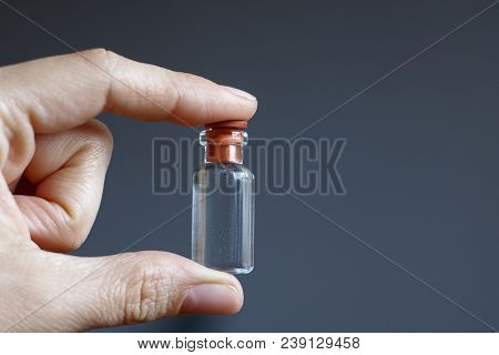 Hand Of A Man With A Small Bottle Of Elixir