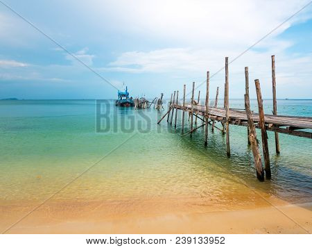 Beautiful Beach With Blue Sky And A Boat On The Dock