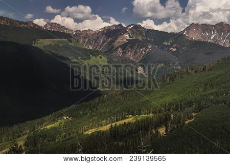 Tree-covered Vail Mountain With Blue Skies And Shadows Cast From The Clouds Above On A Summer Day In