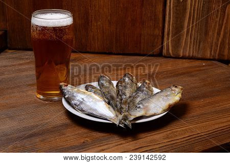 Beer With Dried Fish And Snacks On Wooden Table.