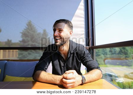 Male Ecologist Sitting At Office On Sofa With Trees In Background. Concept Of Business And Office Wo