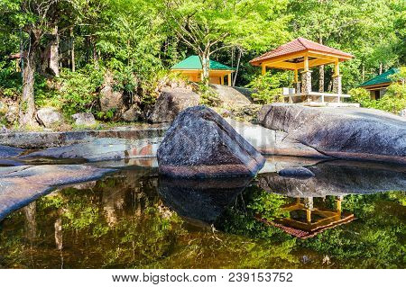 Traditional Japanese Garden With Lake And Pavilion. Reflection In Water.