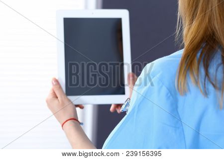 Woman Doctor Using Tablet Computer While Standing Straight In Hospital Office, Closeup. Healthcare, 