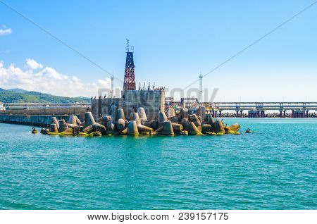Breakwater And Seamark On The Blue Sea. Scenic Seascape On Sunny Summer Day