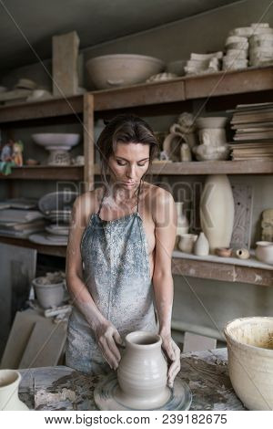 Potter Sculpts A Vase On A Potter's Wheel