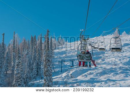The Lift Raises Two Snowboarders To The Mountain. Ski Center. Winter.