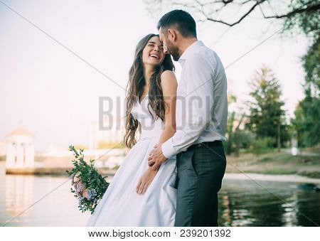 Newlyweds Emotionaly Laught At The Walk Near Pond. Outdoors