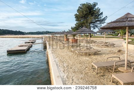 Beach With Beach Chairs In Morning Light On The Beach Of A Croatian Seaside Holiday Resort In Porec,