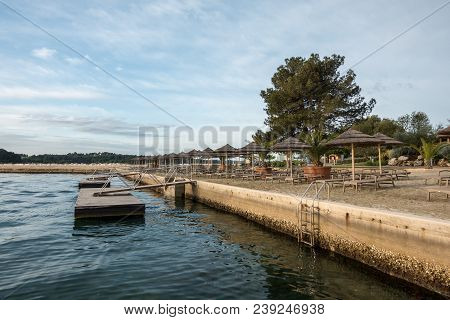 Beach With Beach Chairs In Morning Light On The Beach Of A Croatian Seaside Holiday Resort In Porec,