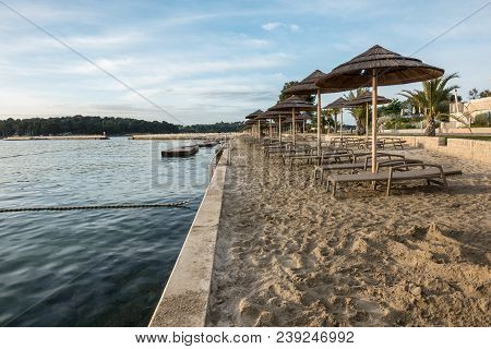 Beach With Beach Chairs In Morning Light On The Beach Of A Croatian Seaside Holiday Resort In Porec,