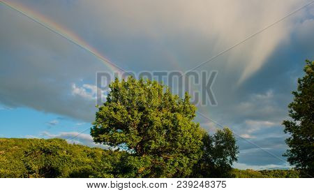Rainbow At The Background Rain Clouds. Spring Season In The Village. Panorama Sky In The Sunny Day.