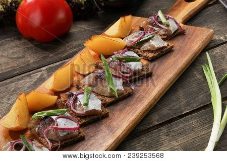 Herring With Baked Potatoes And Onions On Tray On Wooden Background. Restaurant Dish