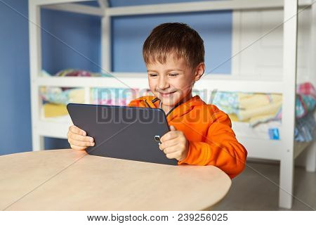 Caucasian Boy Is Using Tablet At Home.