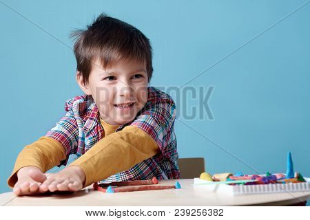Joyful Caucasian Boy Is Crafting With Colorful Modelling Clay.