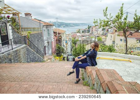 Istanbul, Turkey: Beautiful Girl Sitting On A Stair In Kuzguncuk District With View Of Bosphorus And