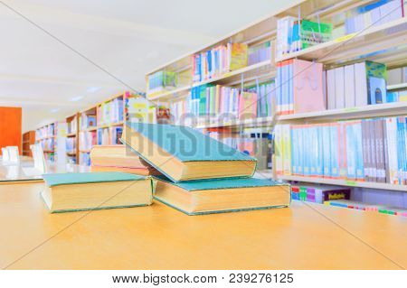 Old Book Red - Green. And Heap Treatise In School Library On Wooden Table.  Blurry Bookshelves Backg