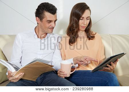 Mature Couple Rading Something On Tablet Computer