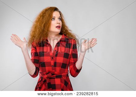 Charming Young Girl In A Checkered Cloth On A Gray Background