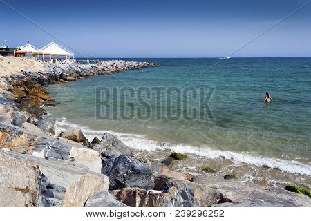 Sanremo, Liguria, Italy - May 23, 2009: Sanremo Rocky Beach With People Paddling In The Sea And Sunb