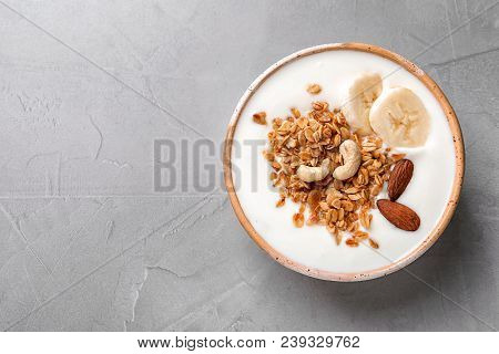 Bowl With Yogurt, Banana And Granola On Gray Background, Top View