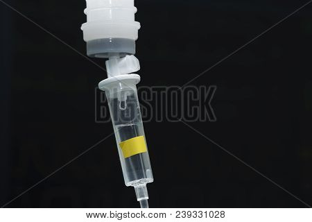 A Drop Fluid From A Plastic Bottle Of Normal Saline On Black Background
