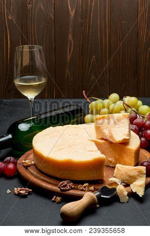 Whole Round Head Parmesan Cheese, Wine And Grapeson Wooden Cutting Board