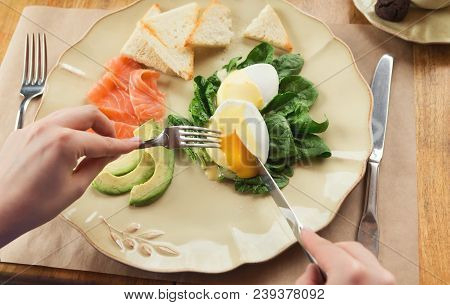 Healthy Breakfast - Poached Eggs With Smoked Salmon, Avocado, Spinach And Crusty Baguette. Woman Eng