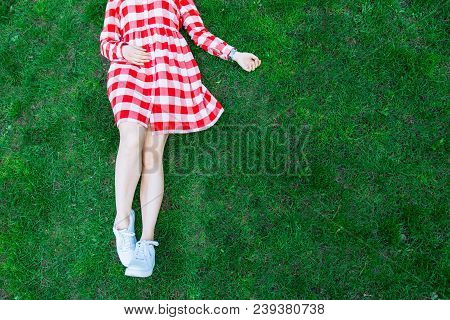 Woman Legs In White Shoes Green Grass On Background