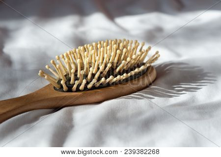 Hair Fall, Hair Loss Problem. Wooden Brown Comb With Hair Loss On White Bed Cover. Woman Healthy And