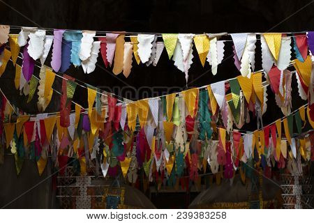 Flag Banner Decoration In Buddhist Temple. Triangle Flags Garland On Dark Background. Cambodian Temp