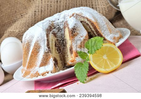 Detail Of Sliced Homemade Lemon Marble Cake Sprinkled With Sugar, Milk, Eggs And Melissa Leaves, Sti