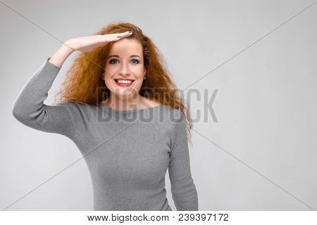 Charming Young Girl With Red Hair. A Young Girl In A Gray Sweater. Young Girl On A Gray Background.