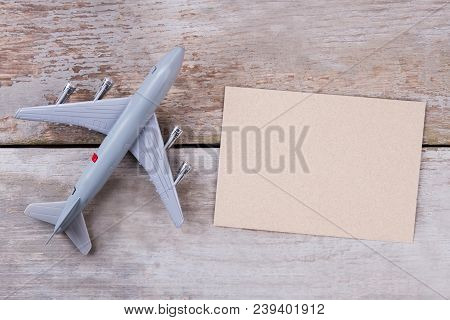 Toy Plane And Blank Postmail. Top View, Flat Lay, Close Up. Wooden Desk Surface Background.