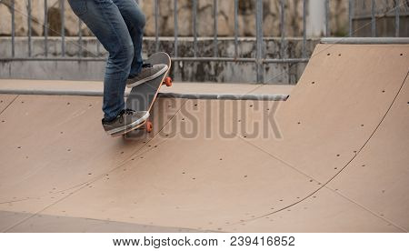 One Woman Skateboarder Sakteboarding On Skatepark Ramp