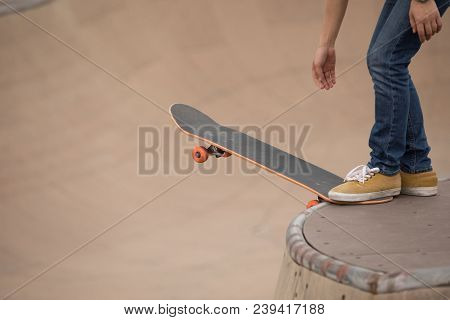 One Woman Skateboarder Sakteboarding On Skatepark Ramp