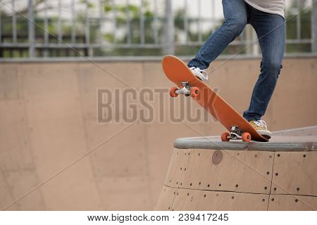 One Woman Skateboarder Sakteboarding On Skatepark Ramp