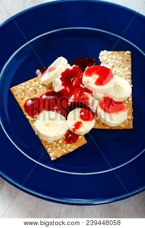Dessert With Dietary Cookies, Banana, Raspberry Topping And Cream Cheese Mascarpone In Blue Plate On