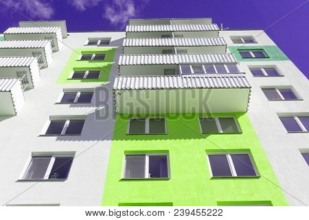 View From Below Upwards On Blue Sky And Multi-storey House